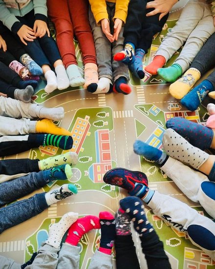 Bambini seduti in cerchio con calzini colorati