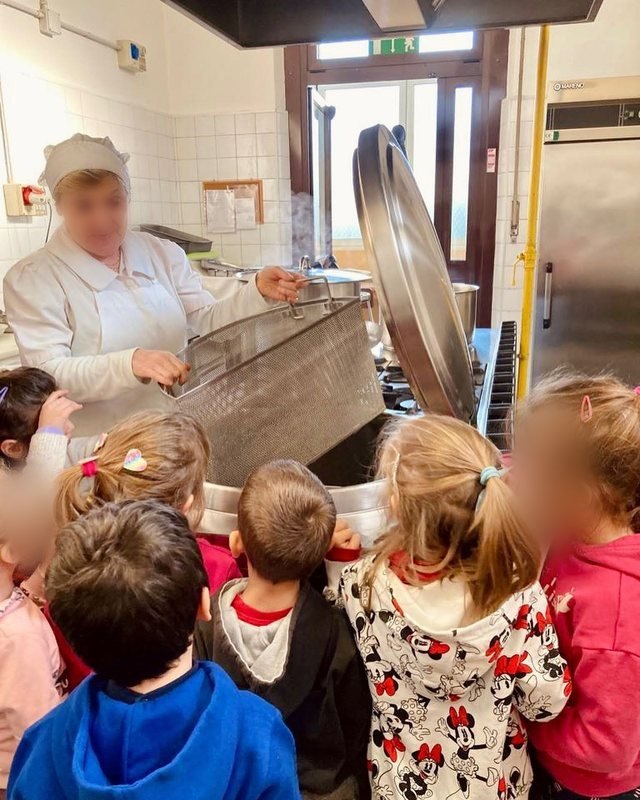 I bambini guardano la cuoca che prepara il pranzo