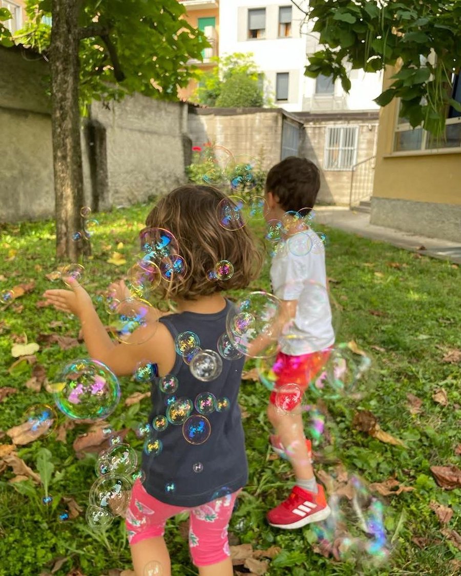 Due bambini giocano tra le bolle di sapone