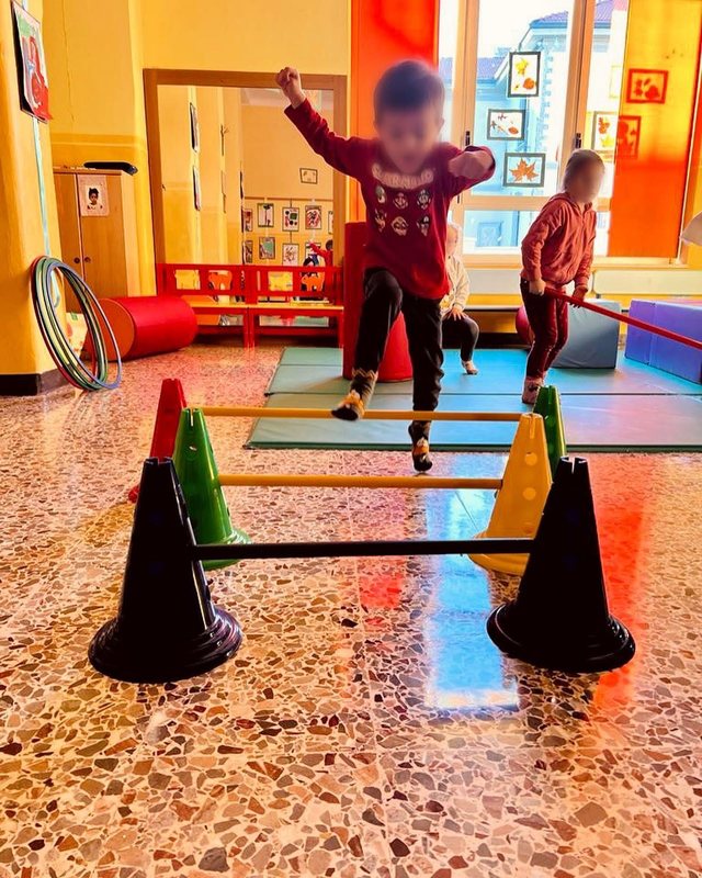 Un bambino salta un ostacolo nel salone